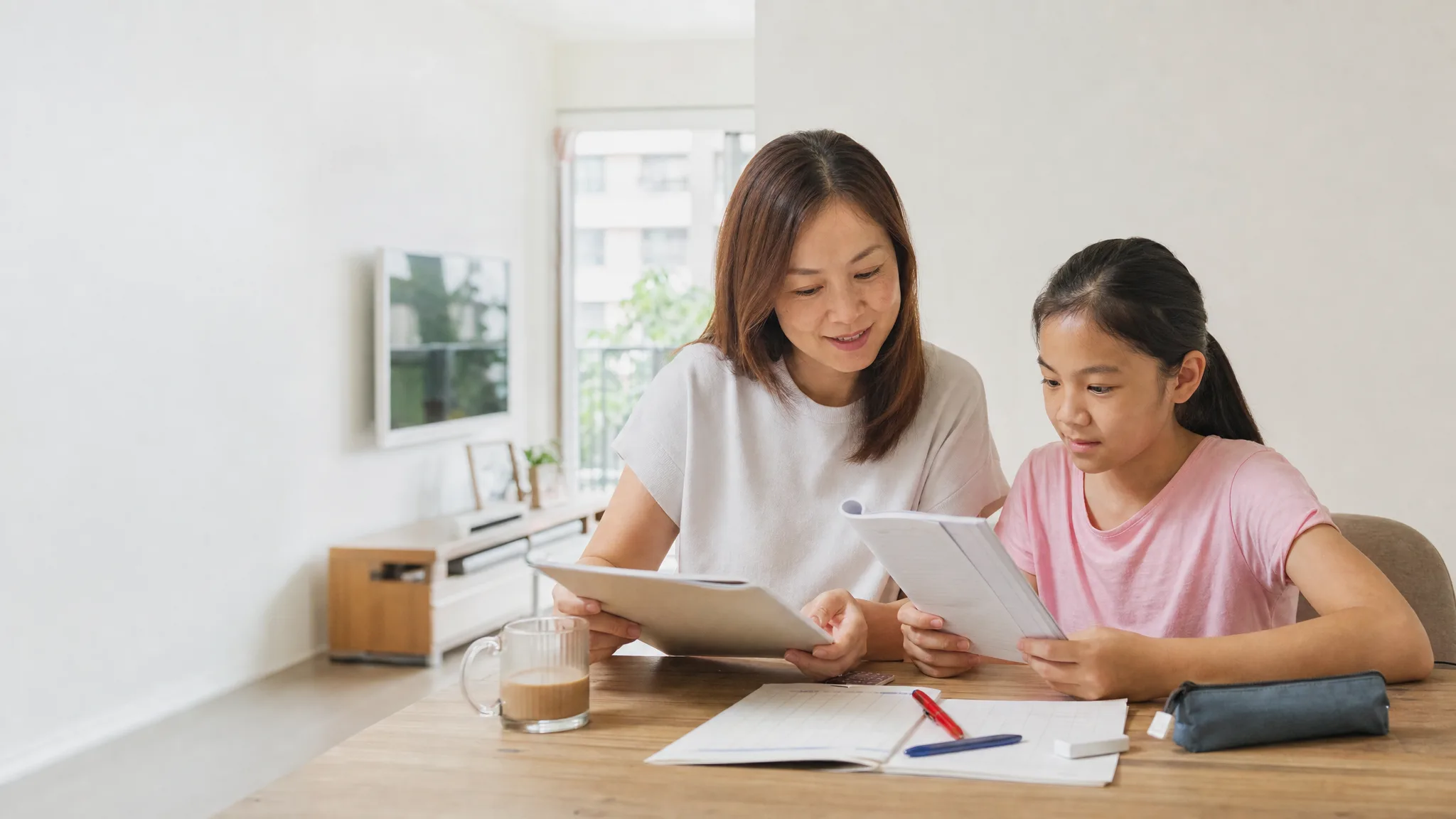 A Singapore parent and child comparing learning resources at home